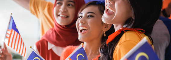 Three smiling women with Malysia flags